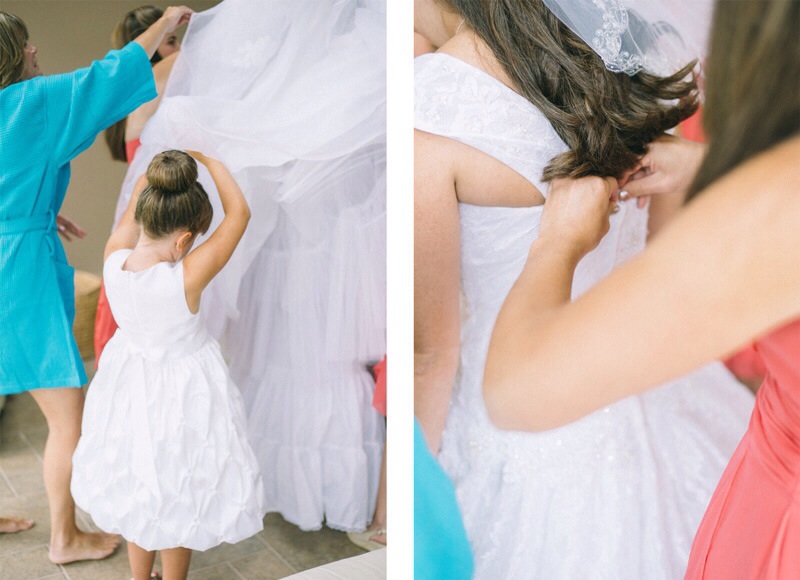 Flower girl helping dress bride