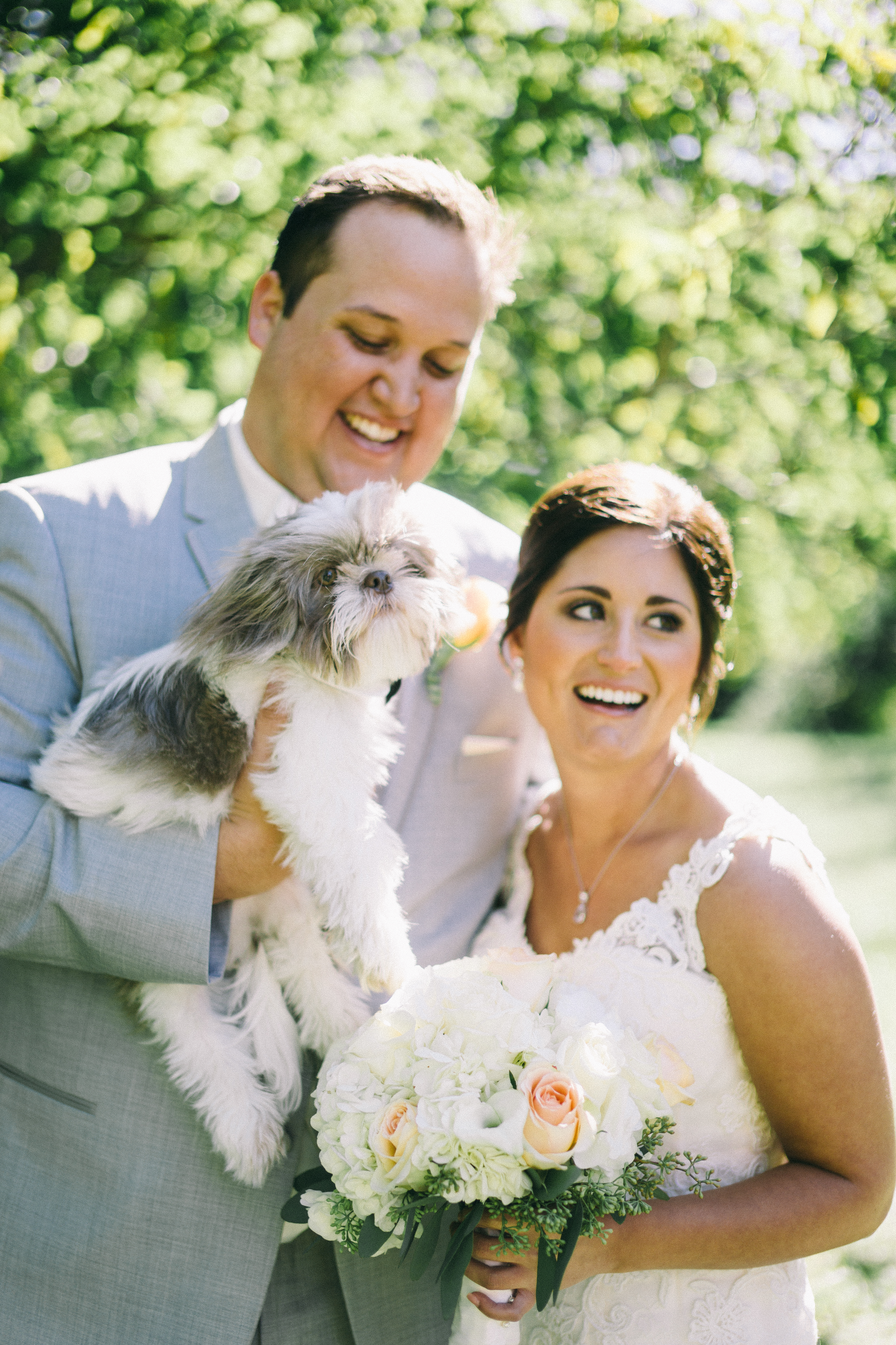 bride and groom with puppy