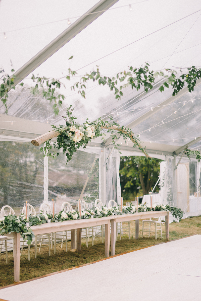 clear tent wedding with drift wood accents