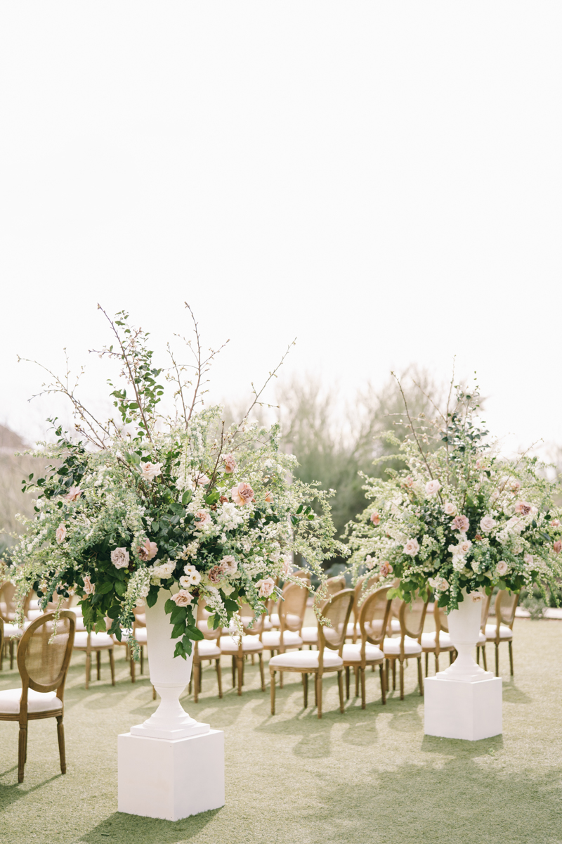 large ceremony flowers in tall white vases