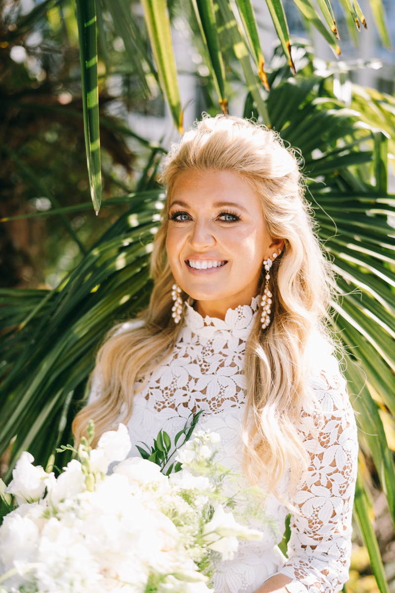 Luxury bride smiling for camera in her wedding dress with flowers