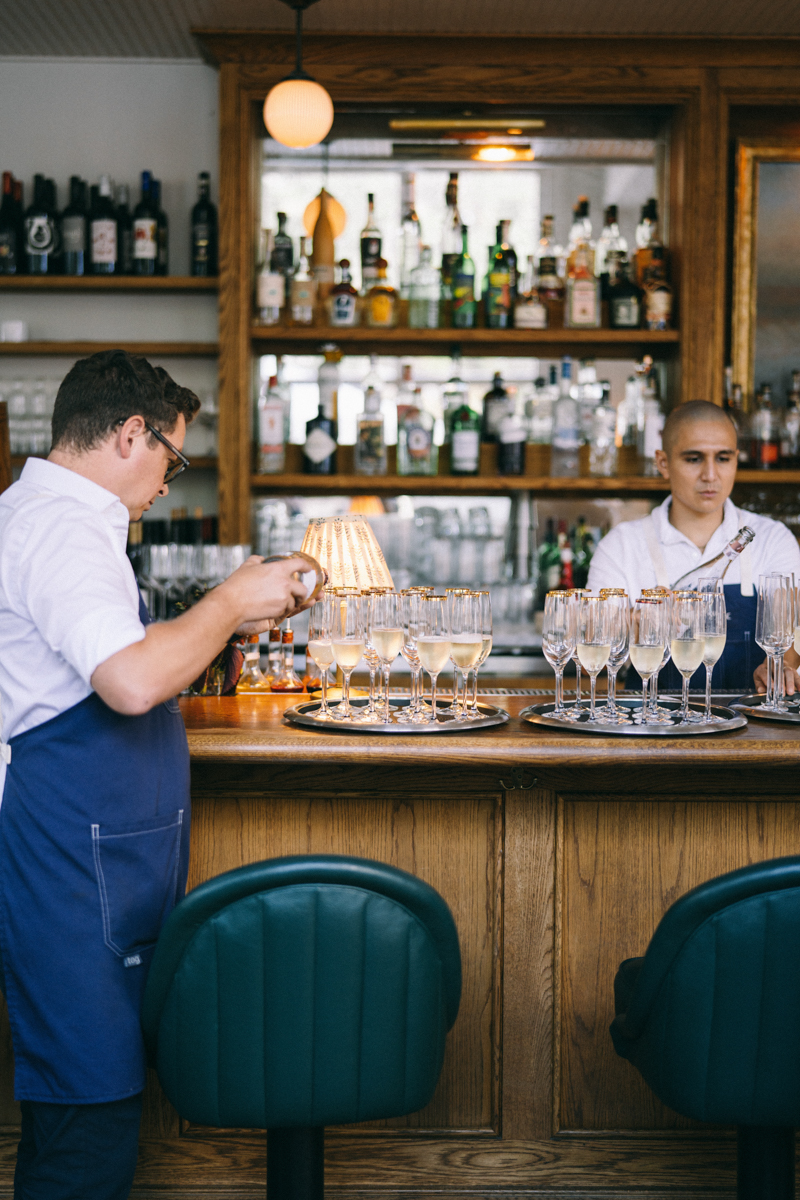 Waiter is ready to bring champagne flutes with gold rims to guests