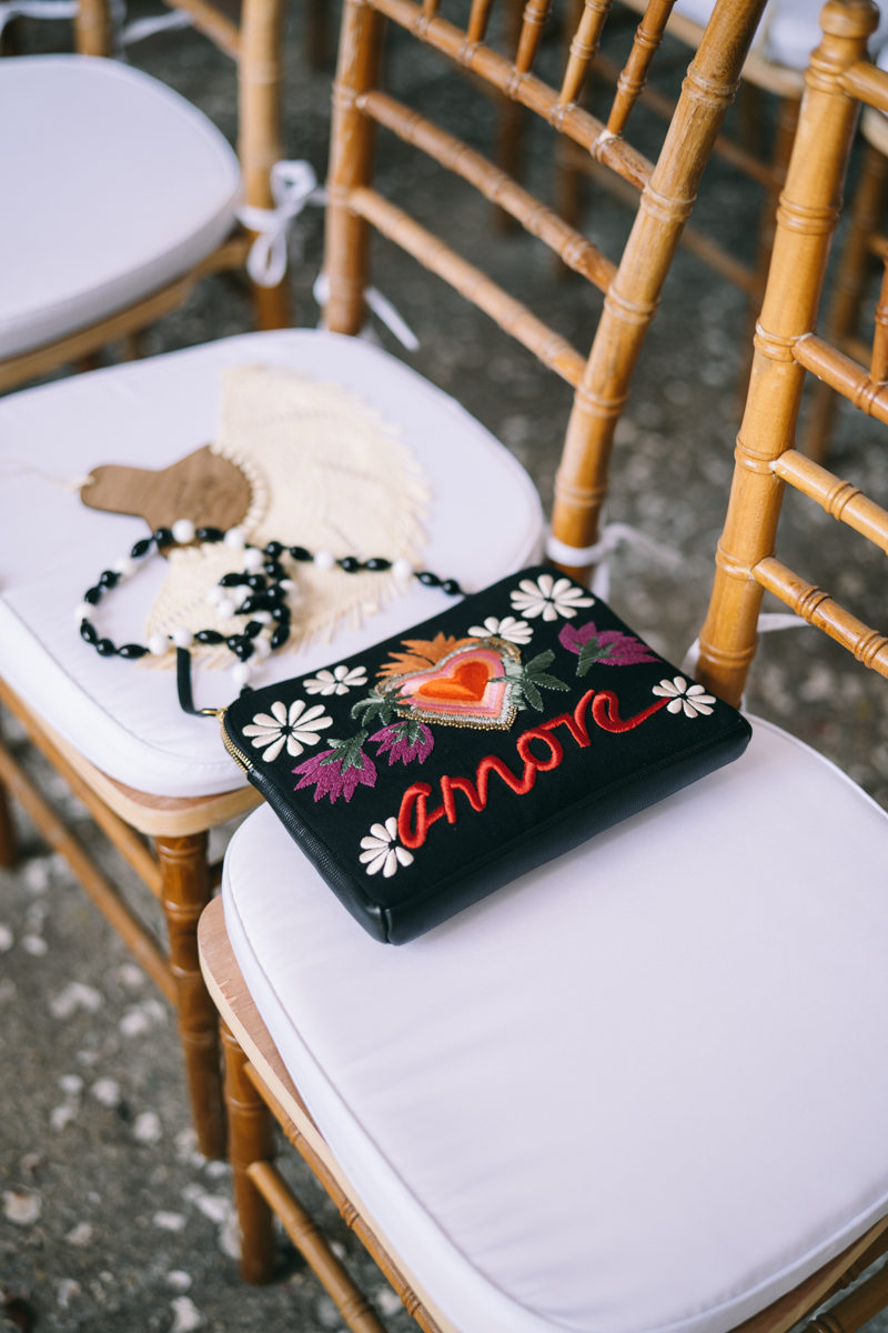 Colorful purse with fan sitting on chair before wedding ceremony