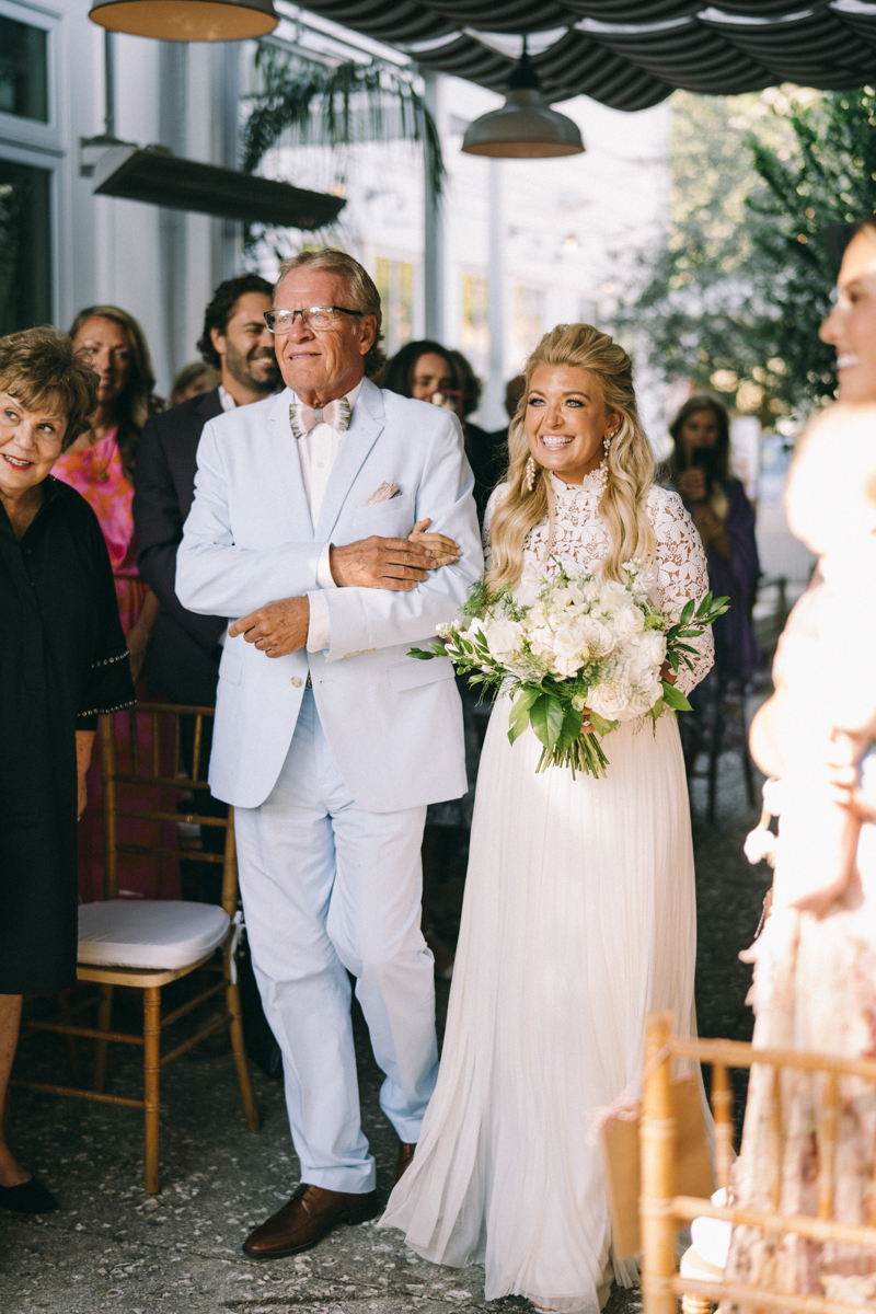 Luxury Bride walking down the aisle with her dad in blue suit