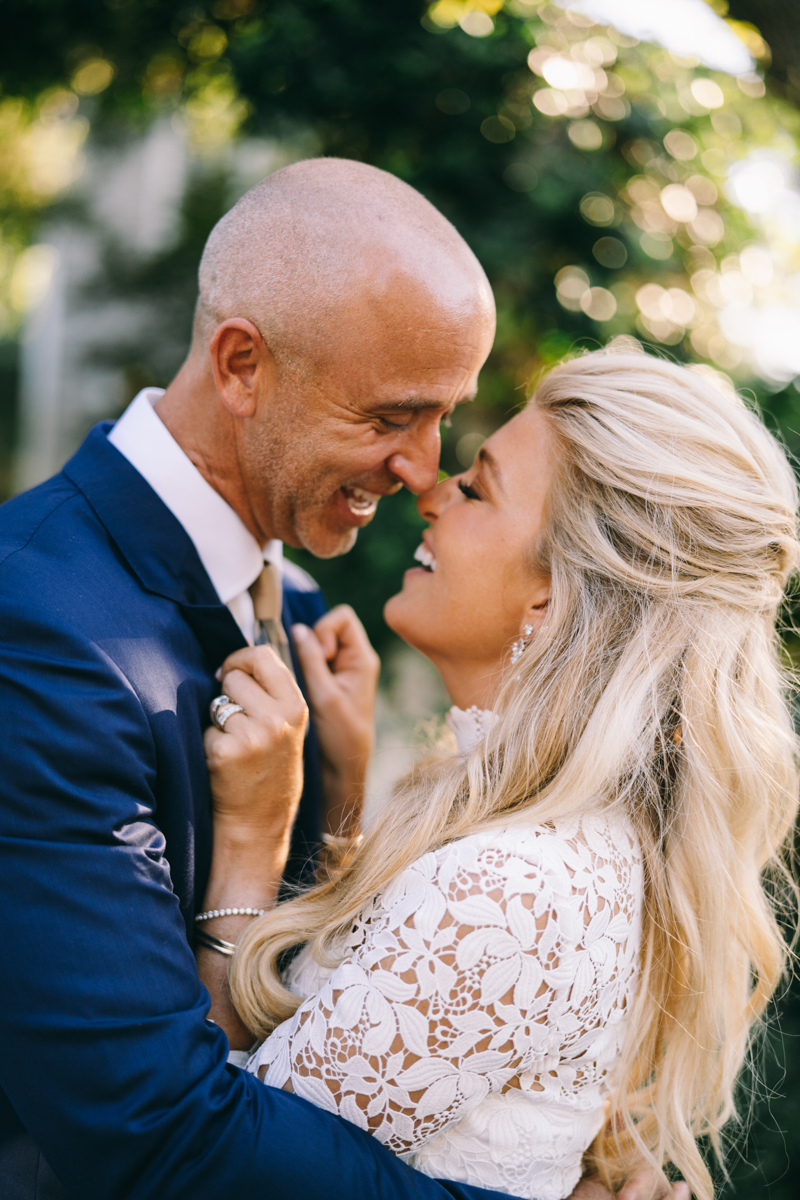 Luxury Bride and groom smiling at each other while bride embraces groom