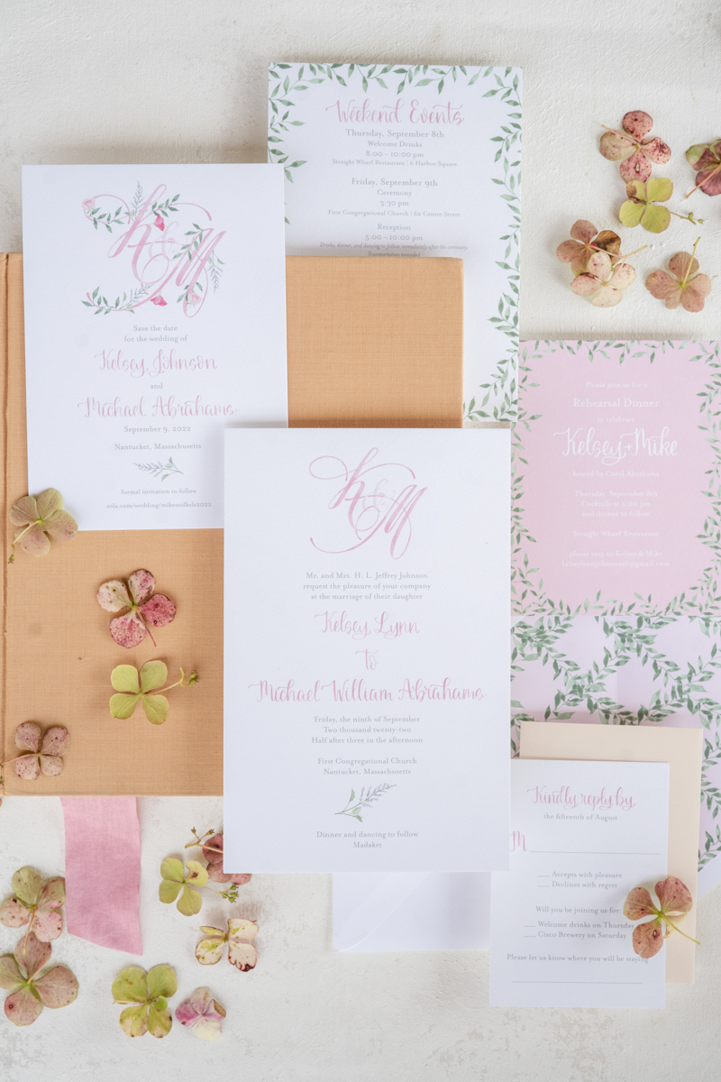 Pink and peach and white wedding invitation on a flatlay