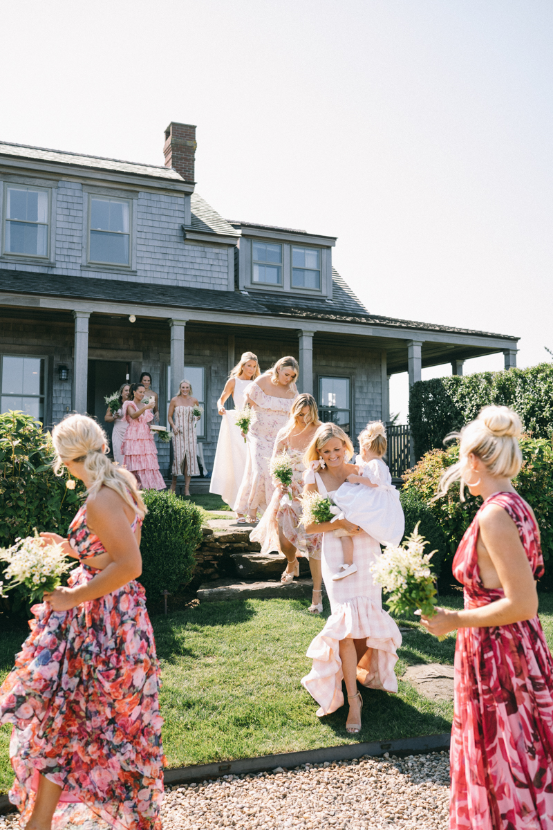 Bride and Bridesmaid holding flowers exiting Nantucket house