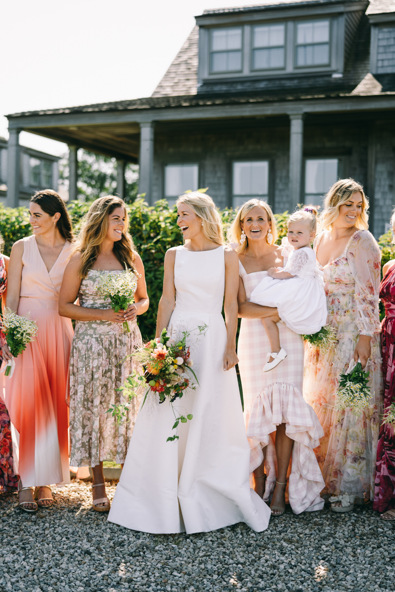 bride with her flowers and some bridesmaids smiling