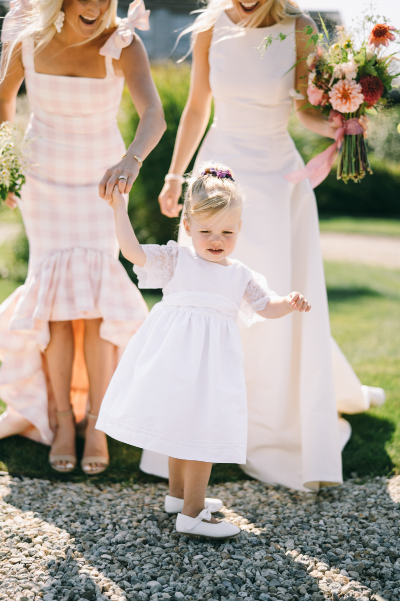 little girl in white dress holding mom's hand
