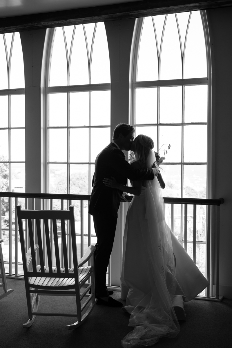 black and white photo of bride and groom kissing