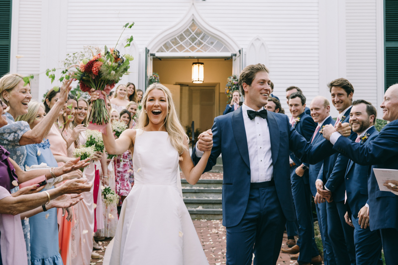 bride and groom leaving church smiling