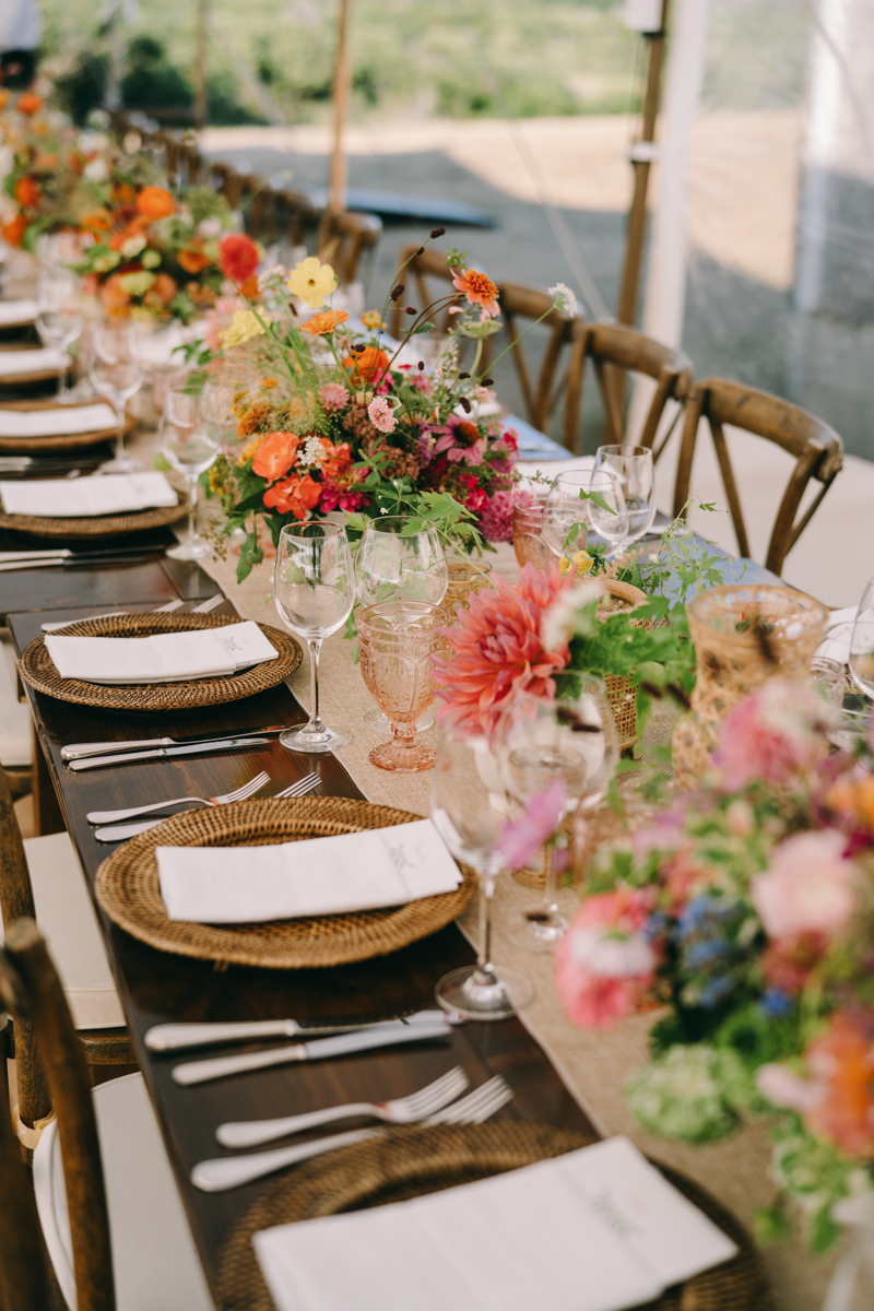 Wedding reception table with pink flowers and plates