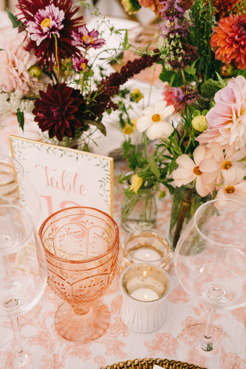 pink glass with purple and pink flowers on table