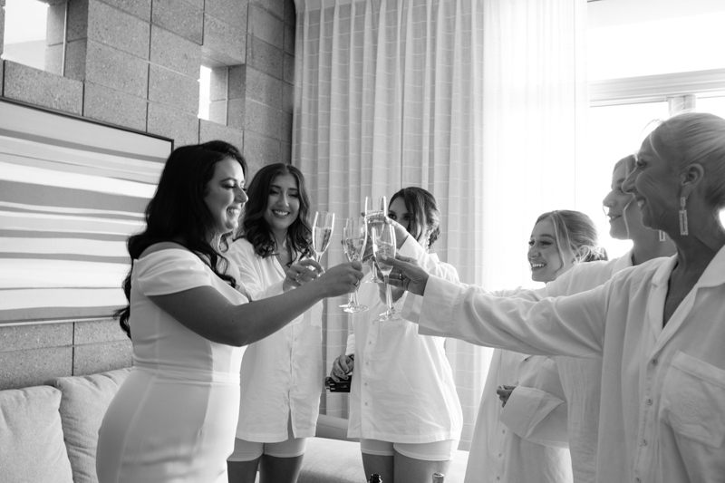 bride cheering with champagne with her bridesmaids