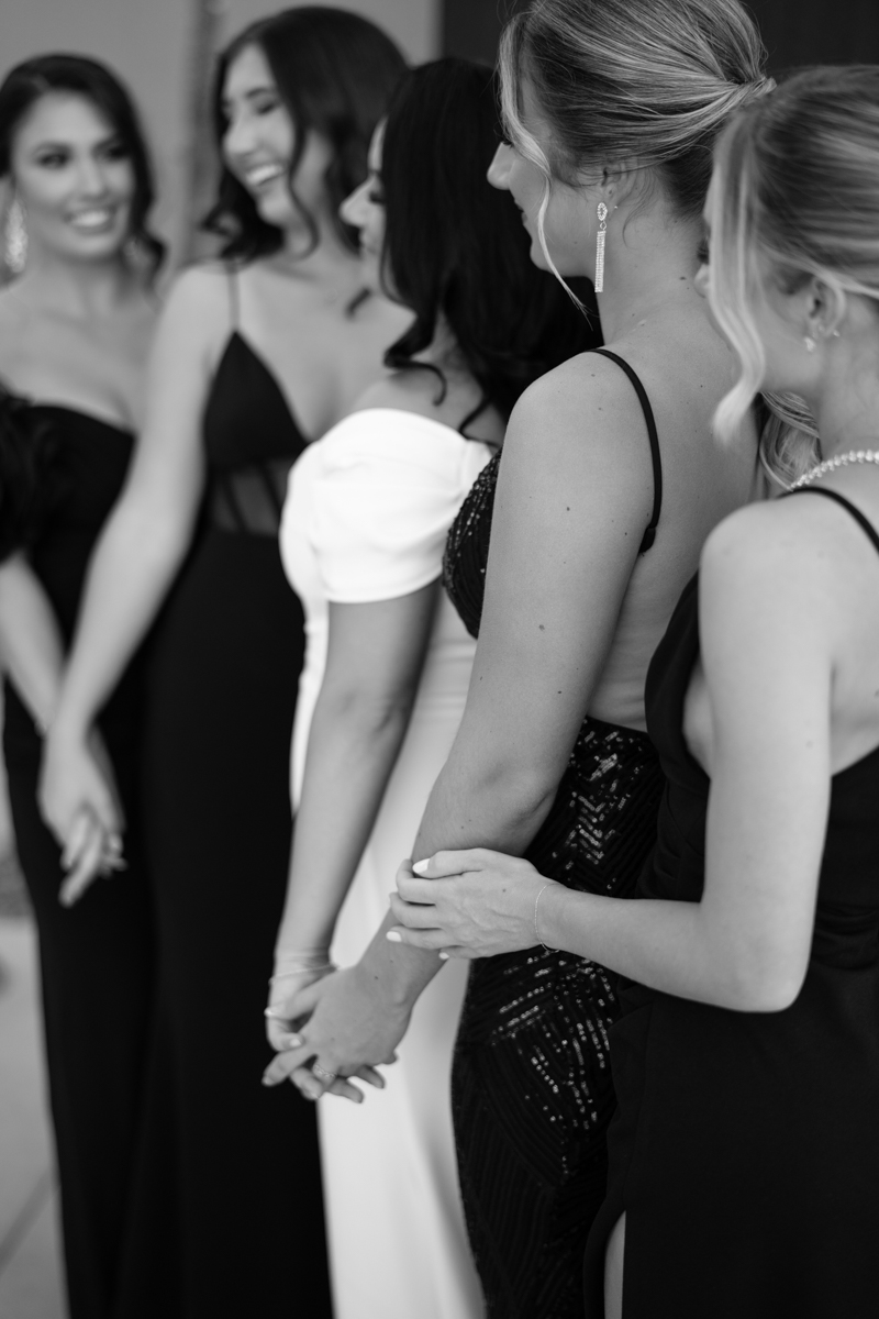 bride and bridesmaids standing together posing for photos