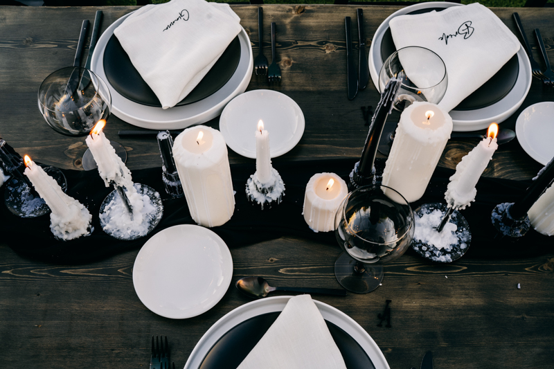 reception table with white candles and white plates with monogrammed napkins 