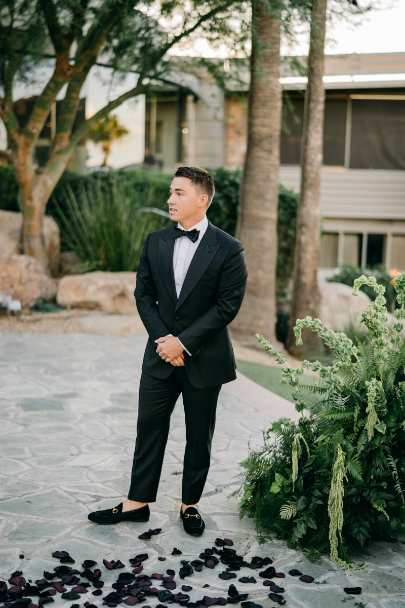 Groom in black tux waiting for bride to walk down the aisle