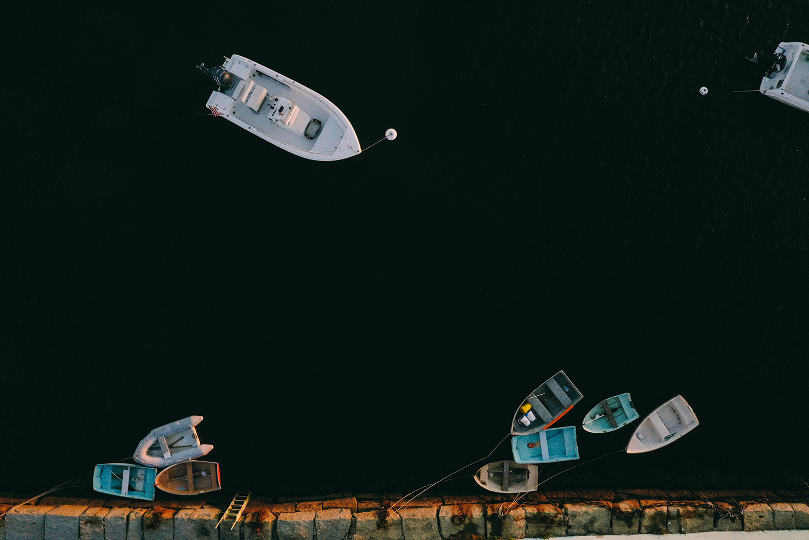Drone shot of one big boat and several smaller boats tethered together in Massachusetts 