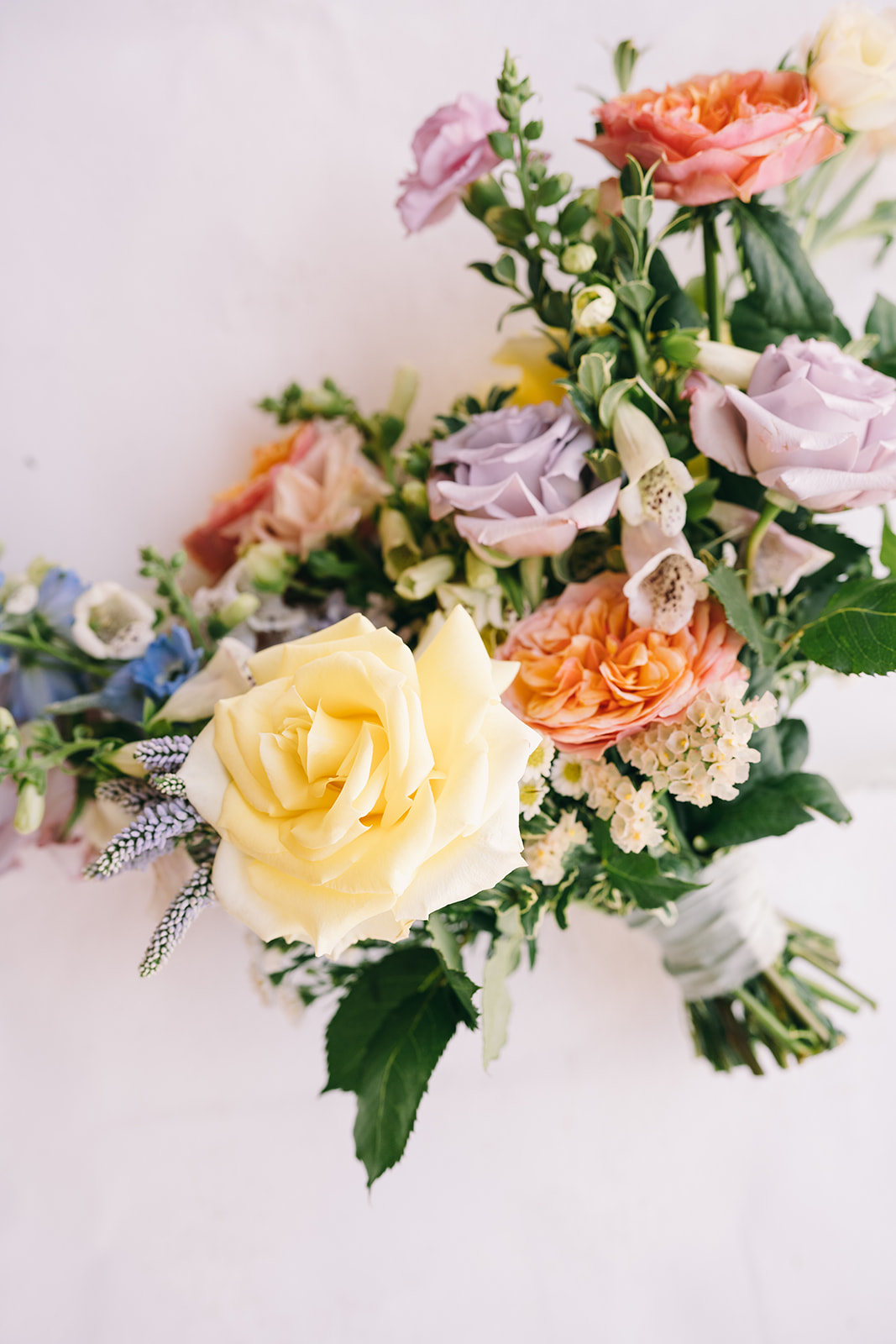 Close up of short stemmed bridal bouquet with yellow and pink roses 