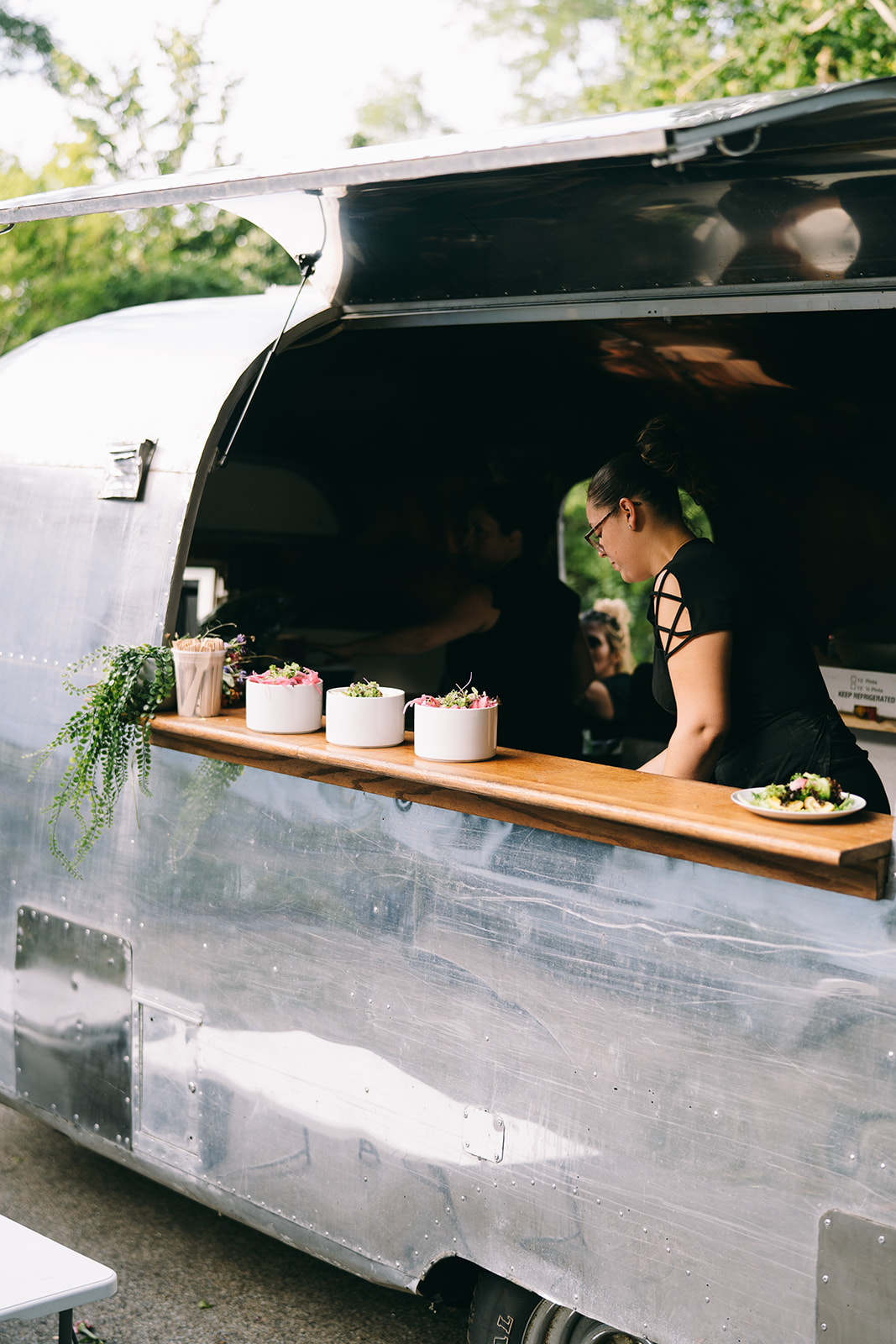Wedding vendor in an airstream serving salads