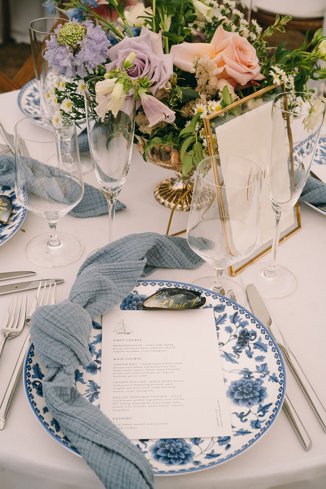 Close up of wedding menu with blue napkin with an oyster with the name 'Caitlin' on it