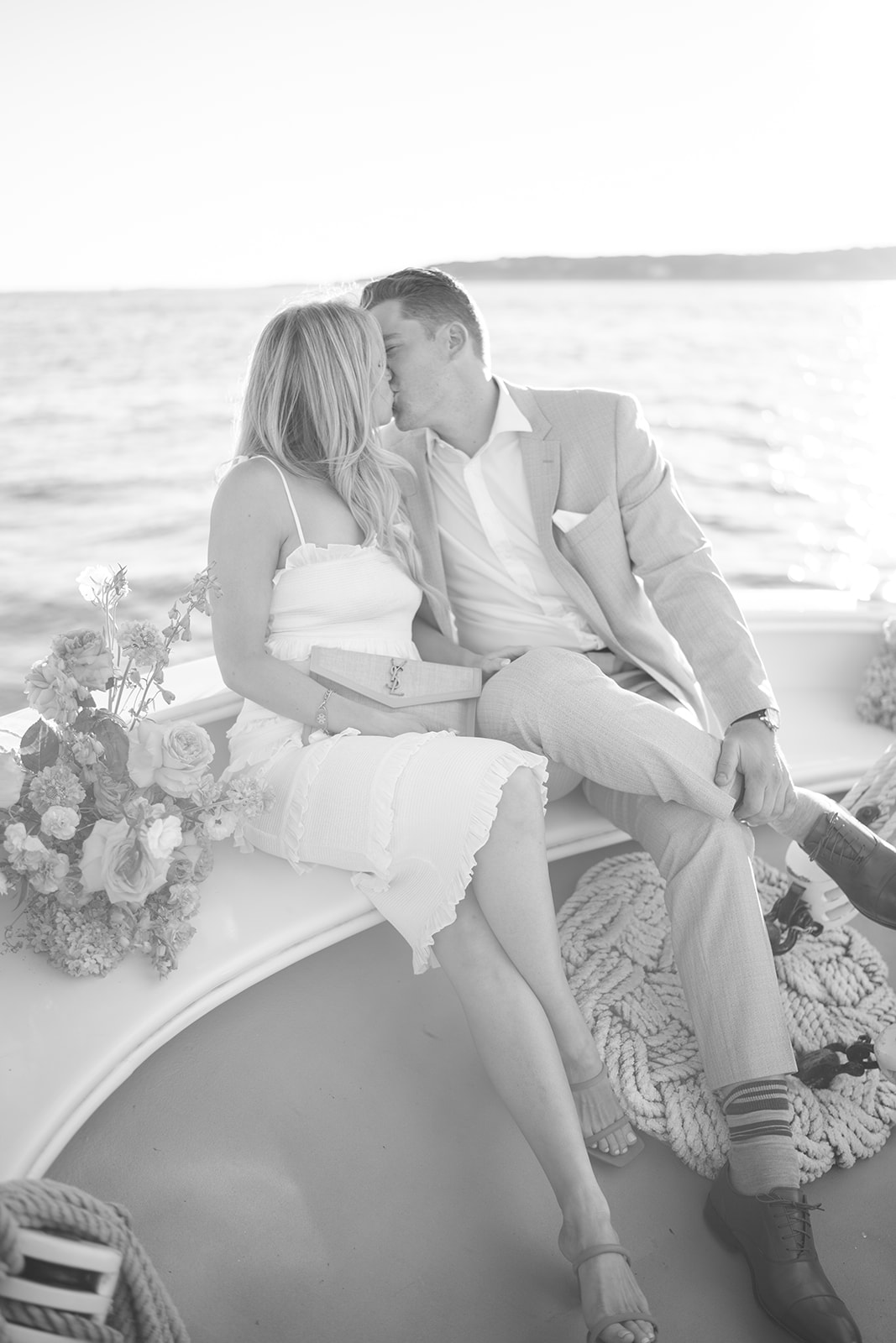 Couple celebrating their wedding on a sailboat share a kiss 