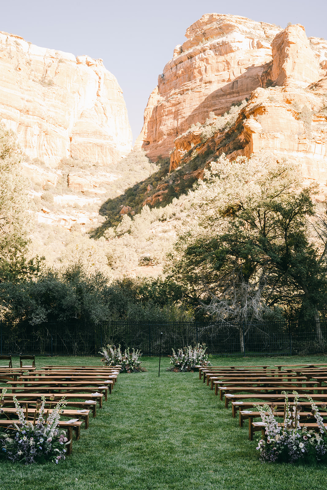 Wooden benches on the grass with the mountains in background, ready for wedding ceremony 