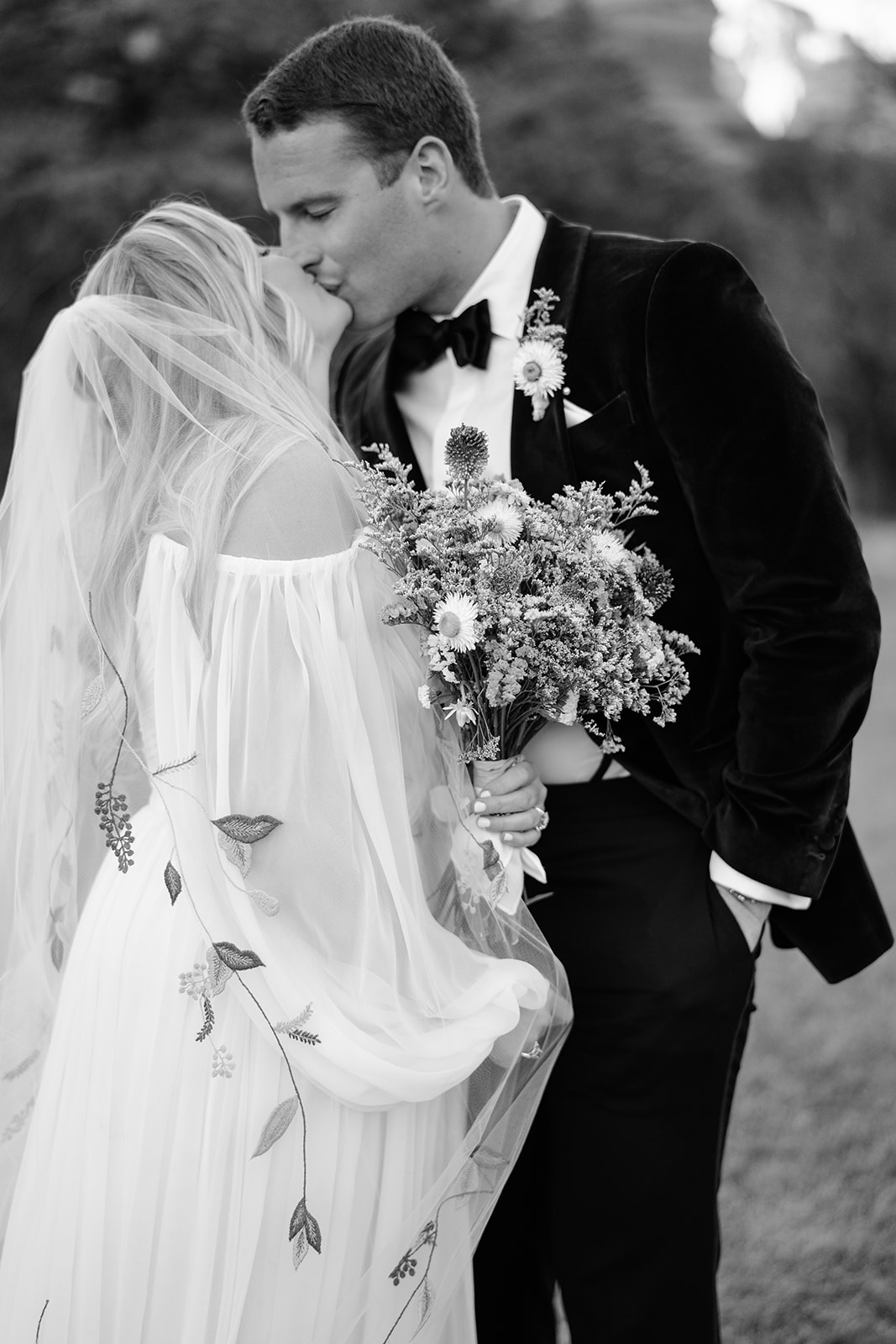 Close up of bride and groom kissing while bride is holding the bouquet