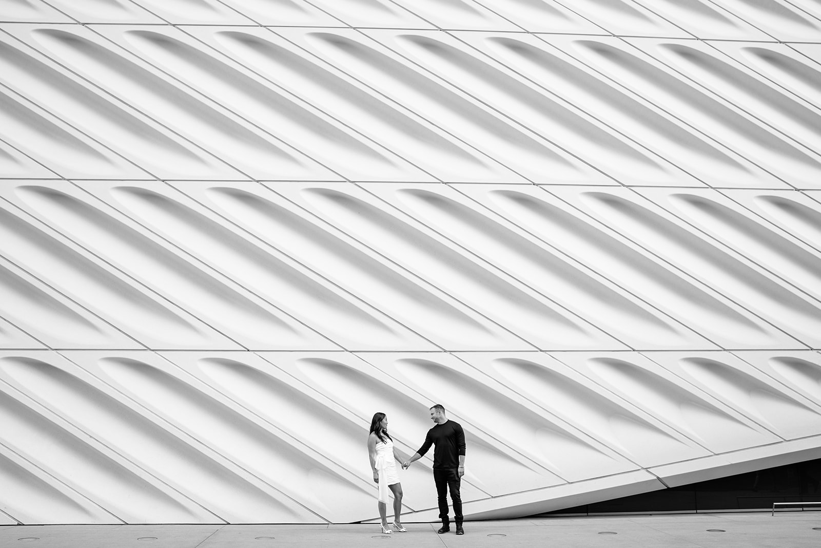 Couple in front of a giant carved wall that makes the couple look very small