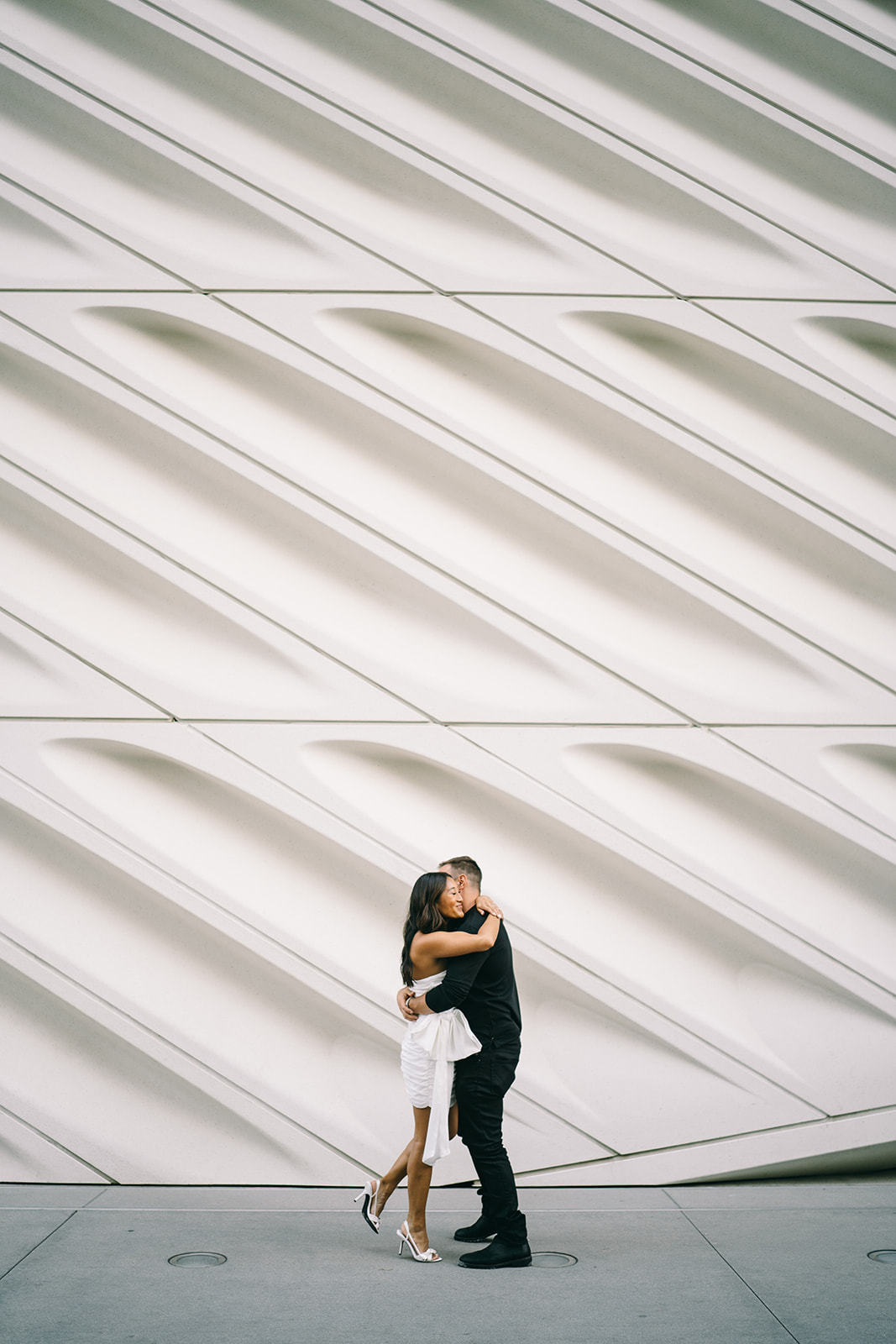 Man hugging woman in front of columned wall