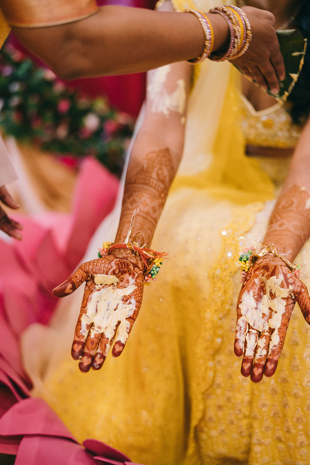 Outstretched woman's arms with henna and haldi on her palms