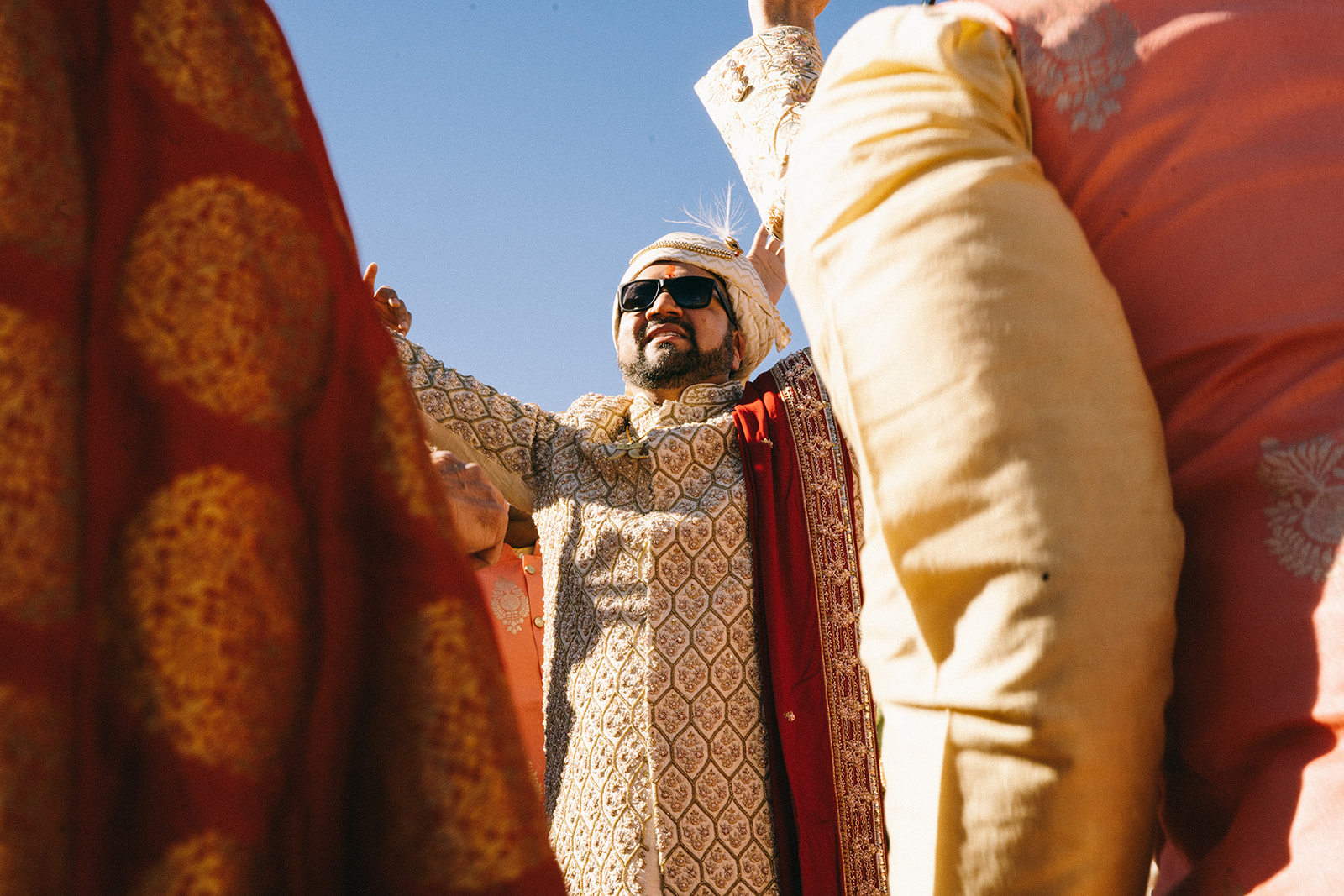 Looking up at a man looking straight ahead wearing sunglasses 