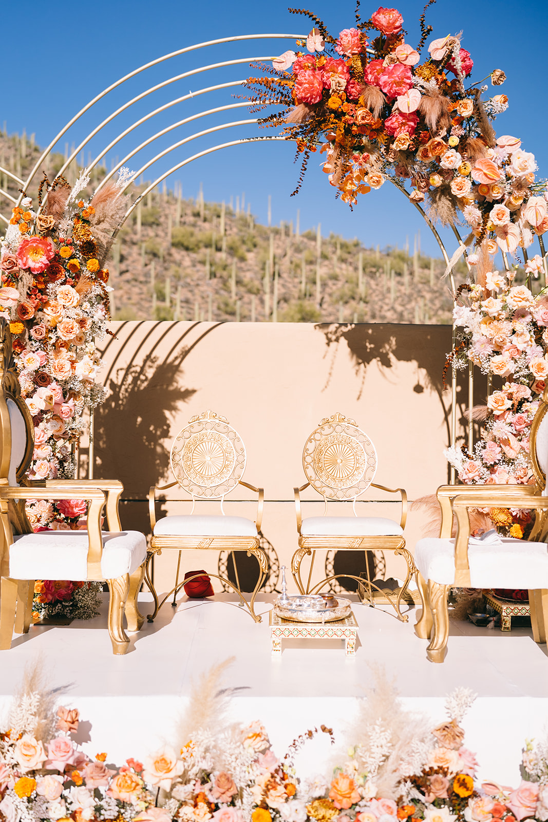 Golden wedding chairs and flower arches in the desert