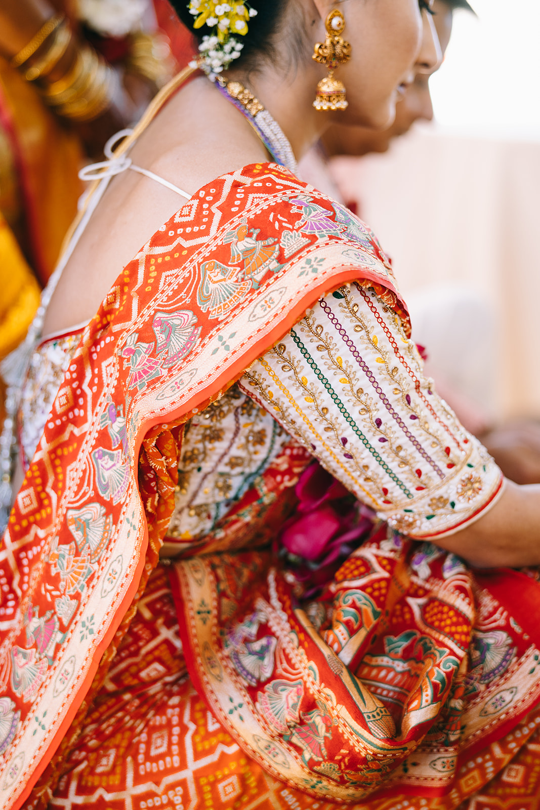 Indian woman with praying hands in yellow wedding saari smiling with eyes closed and haldi on her face and arms