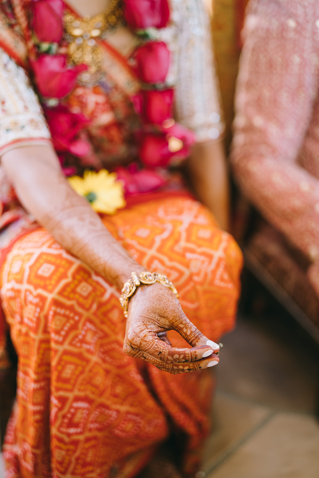 Woman resting her hand on her leg with henna on arms 