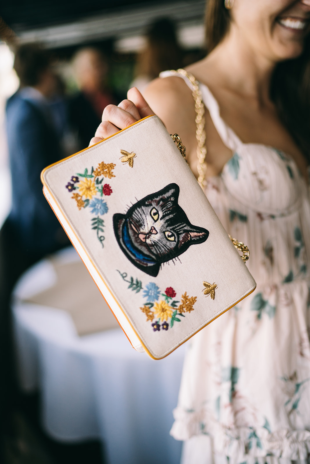 Women showing the front of her purse which has a cat on it 