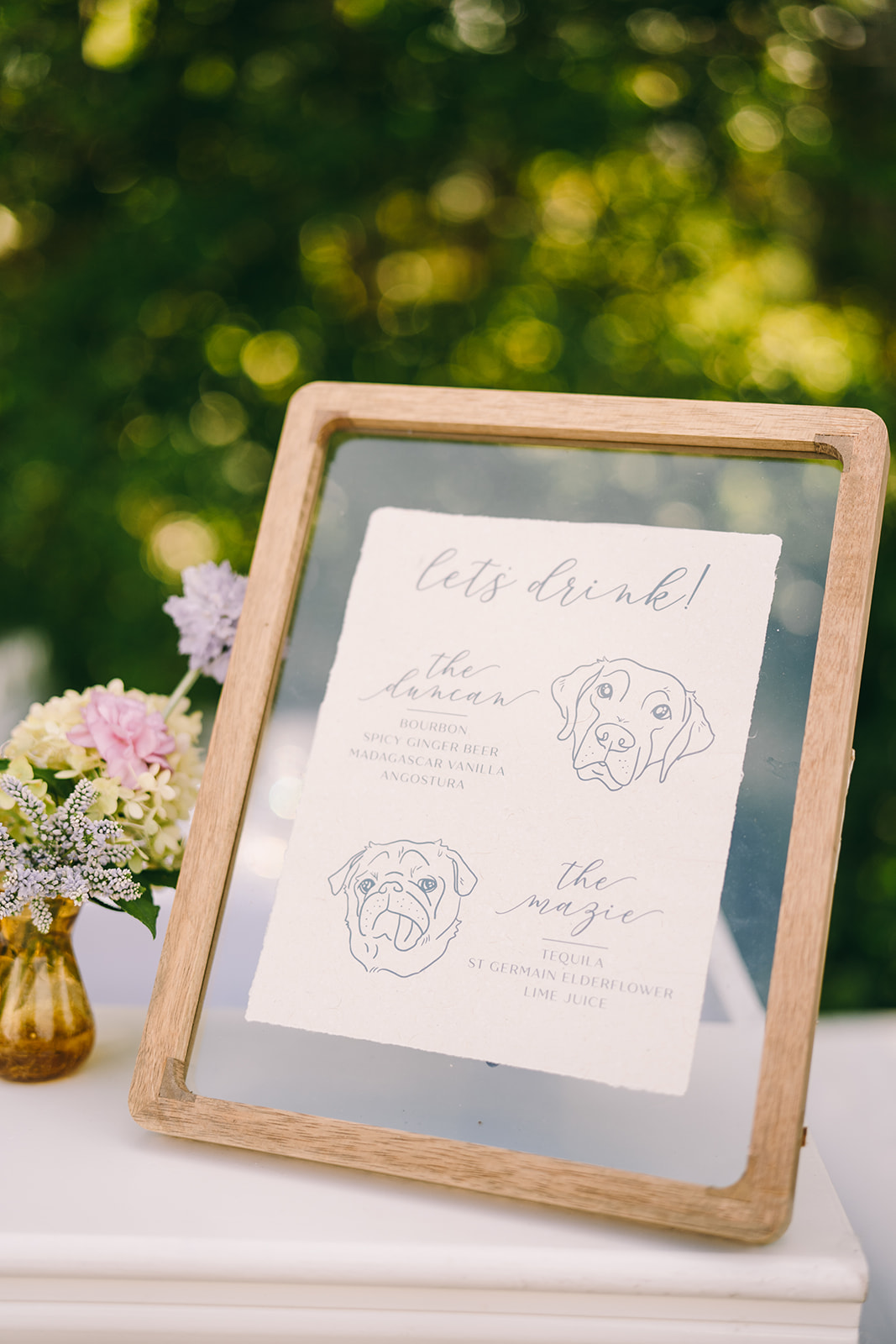 Framed menu of signature drinks with dog sketches and description of the drink