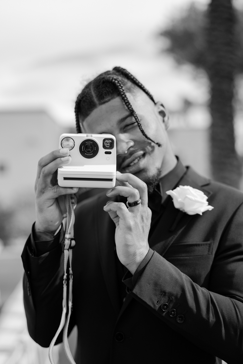 groom shooting a polaroid