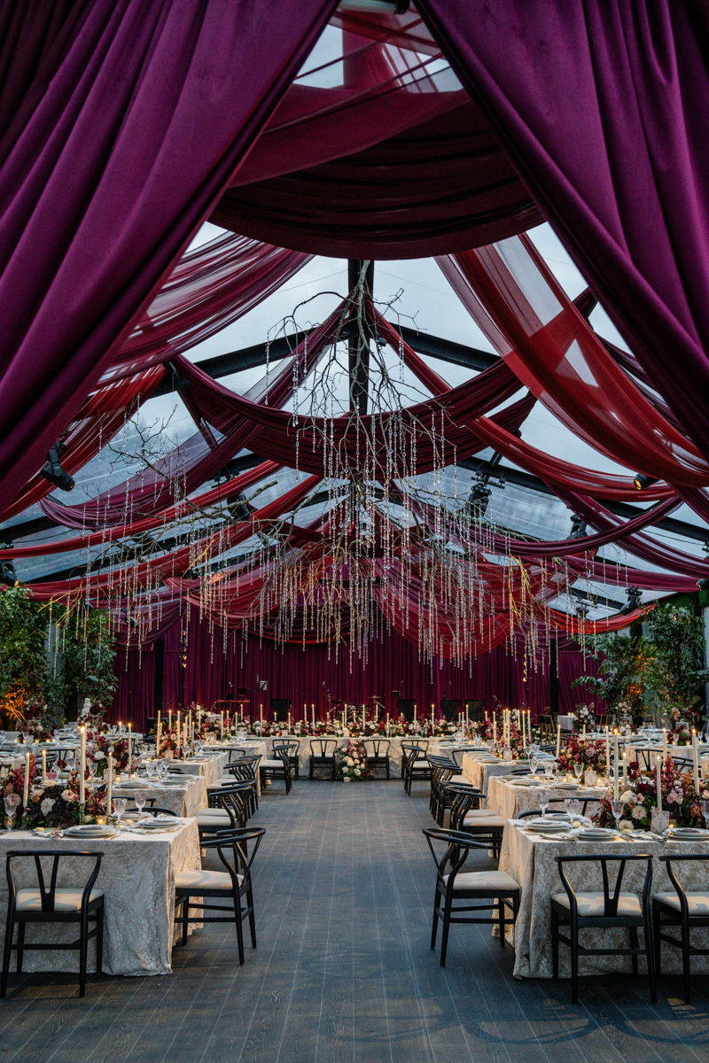 Tented maroon wedding with crystal chandelier