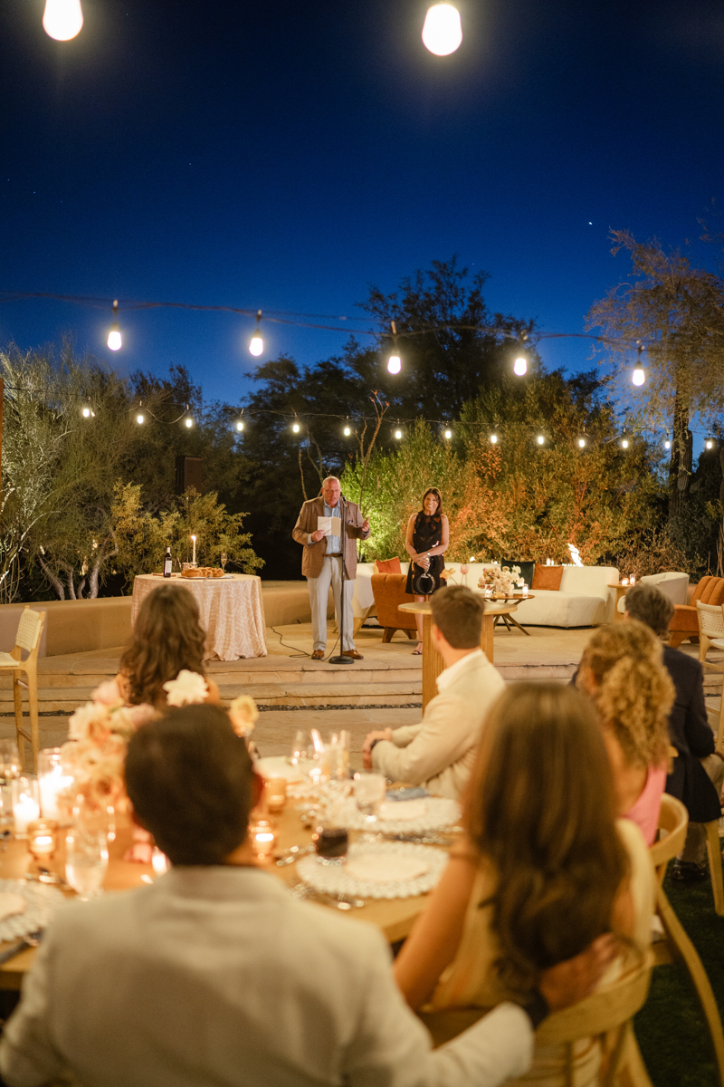couple listening to speeches at rehearsal dinner