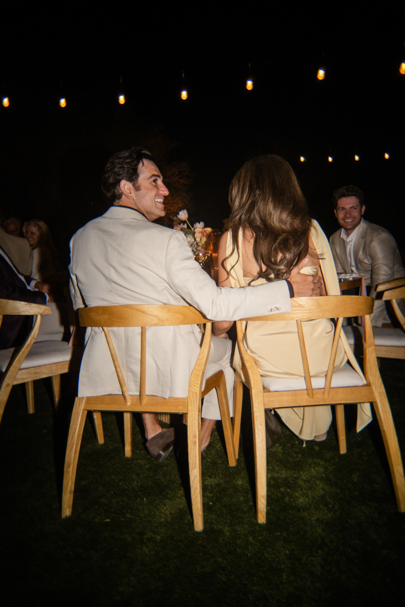 couple listening to speeches at rehearsal dinner
