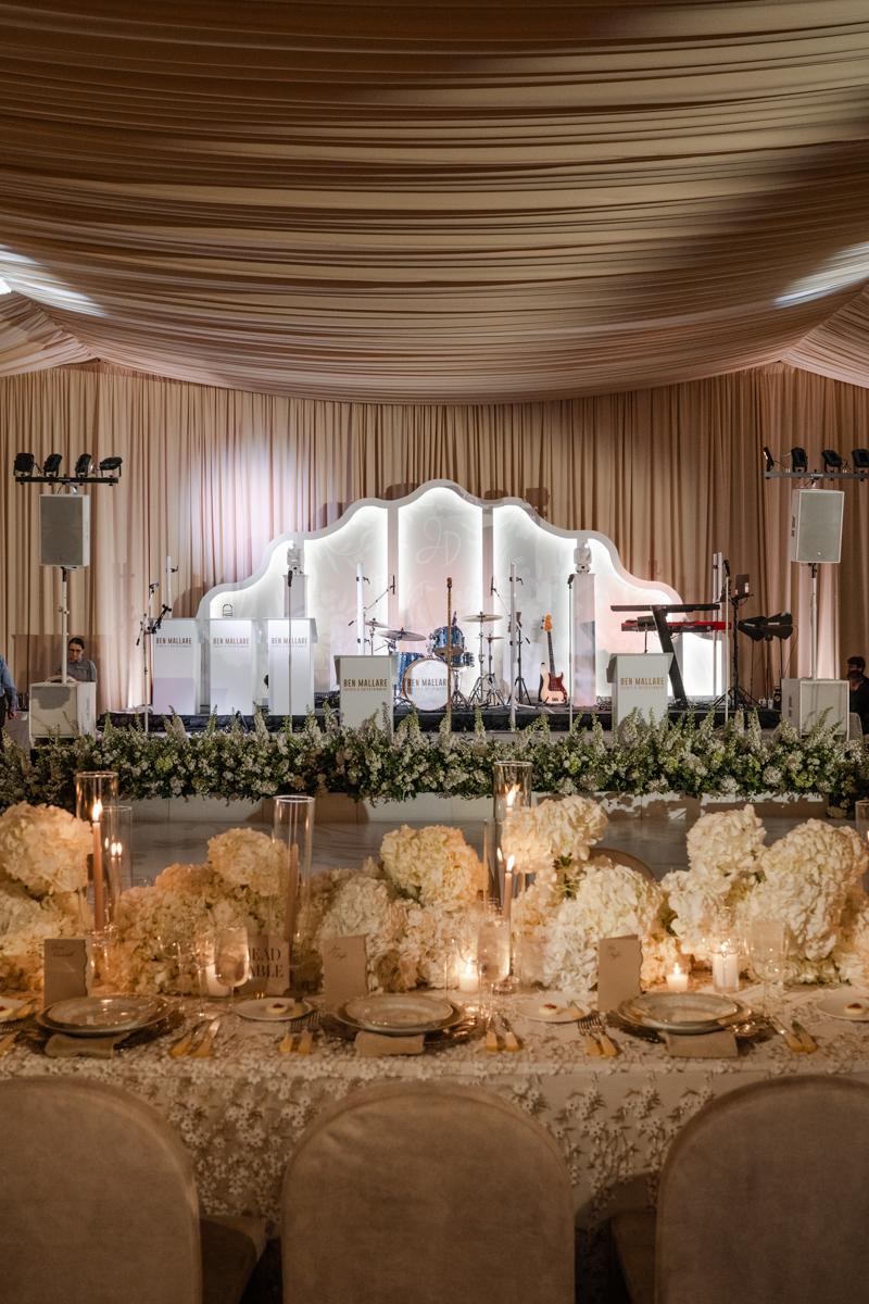 draped ballroom with candles and custom band backdrop