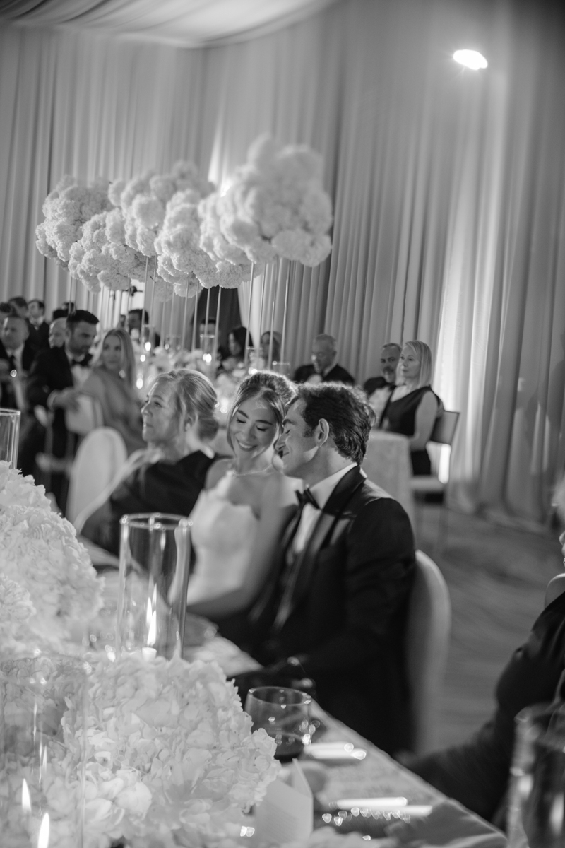 bride and groom watching speeches