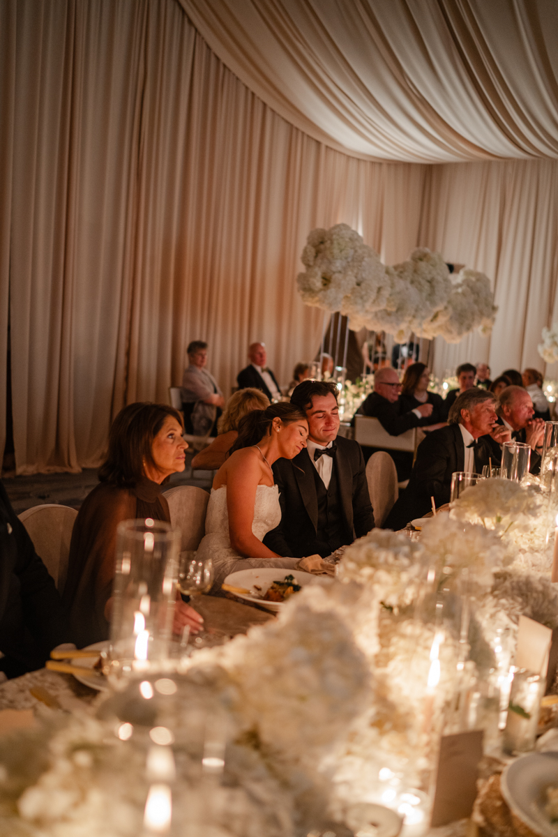 bride and groom watching speeches
