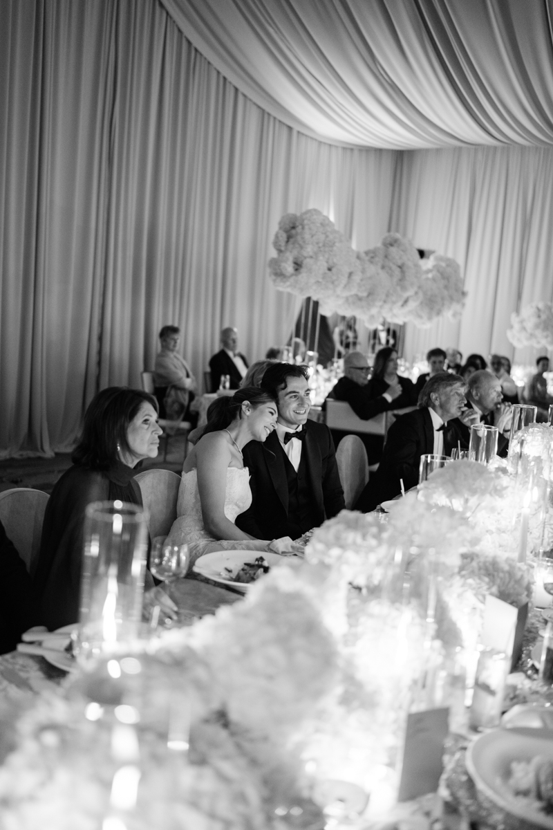 bride and groom watching speeches